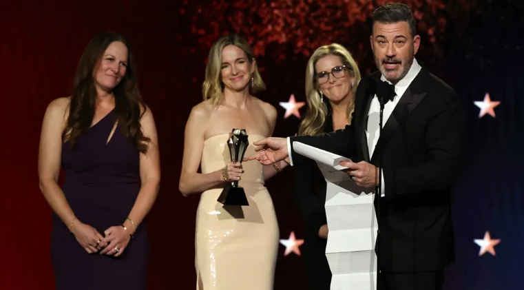 Jimmy Kimmel con su premio Critics Choice y Donald Trump molesto al fondo.