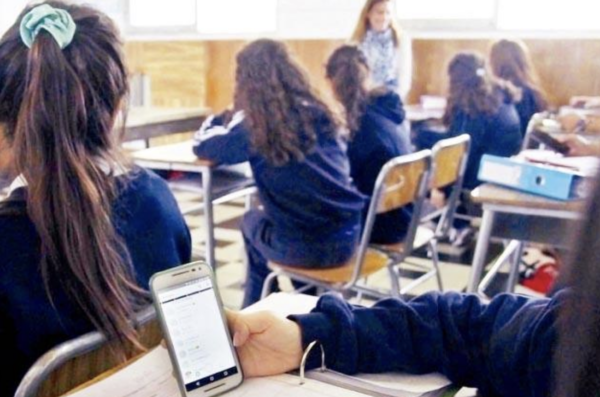 Estudiantes En Aula Durante Discusión Pública Sobre El Uso Responsable De Celulares En Escuelas.